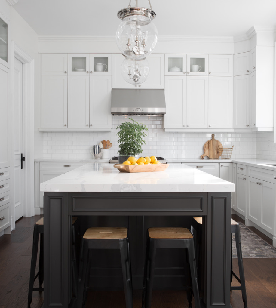 All white modern kitchen with a black centre island with black stools.